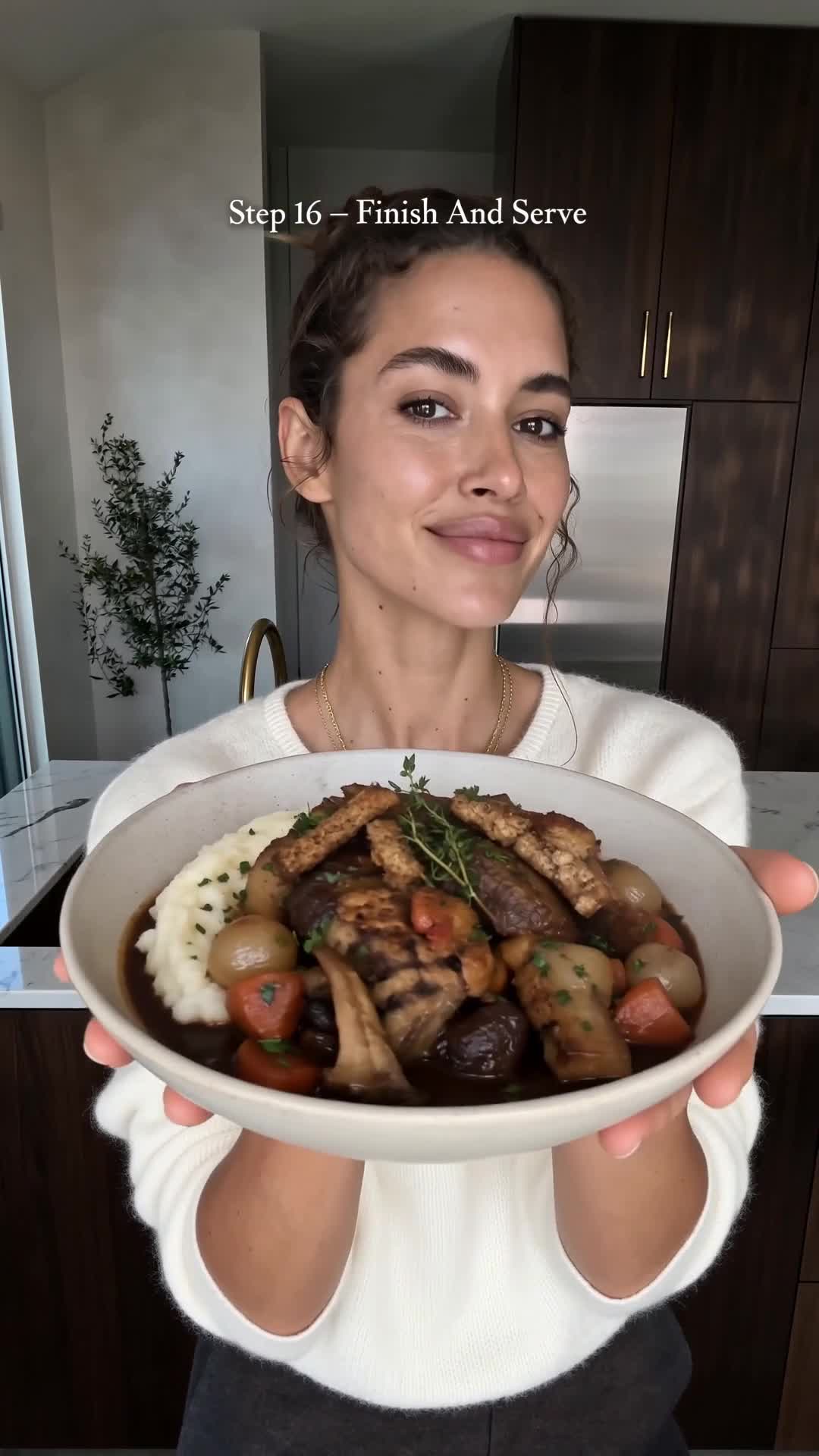 Vegan Coq au Vin plated in a shallow bowl with mashed potato, king oyster mushrooms and red wine sauce